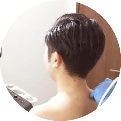 男性の肩にエコーを当てて診察している様子